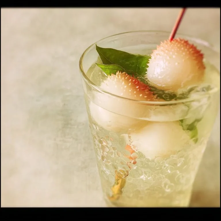 Refreshing lychee mocktail with tropical fruits in a glass